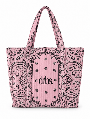 A pink quilted tote bag with a black paisley bandana print and the brand name 'DIBS.' printed in black on the front center panel, set against a plain white background.