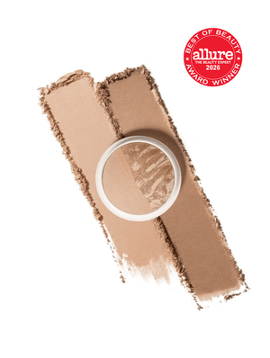 A makeup powder pan with a clear lid placed over two angled swatches of the same beige-brown cosmetic powder on a white background, plus a red Allure Best of Beauty 2026 award badge in the top right.