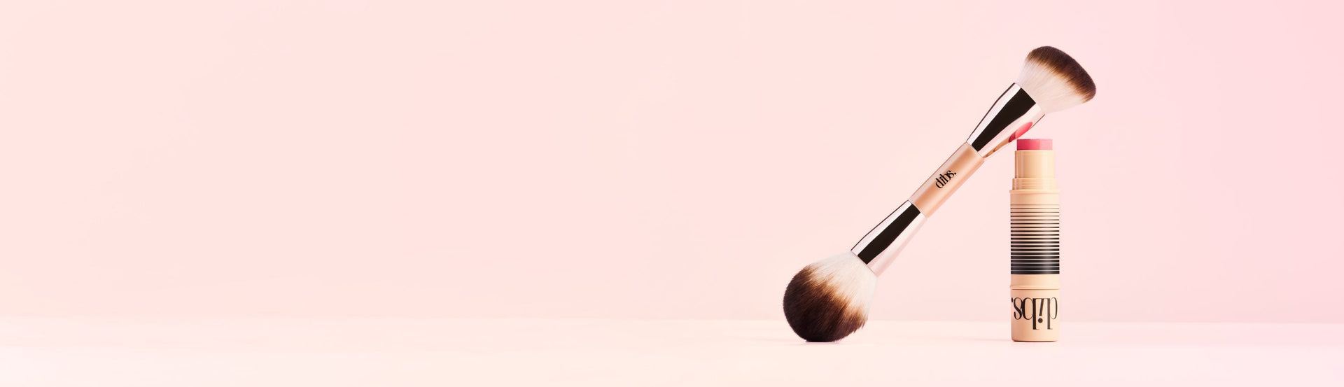 Makeup brush with a pink gradient background