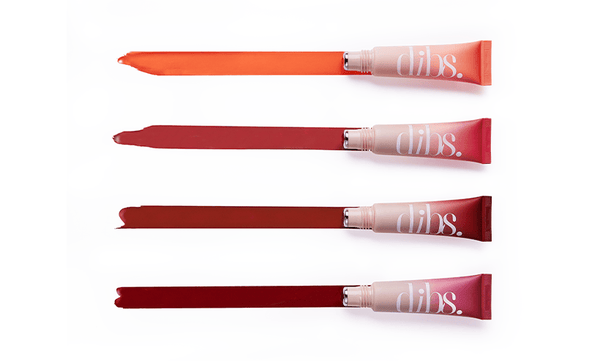 Four liquid blush tubes in different colors on a white background