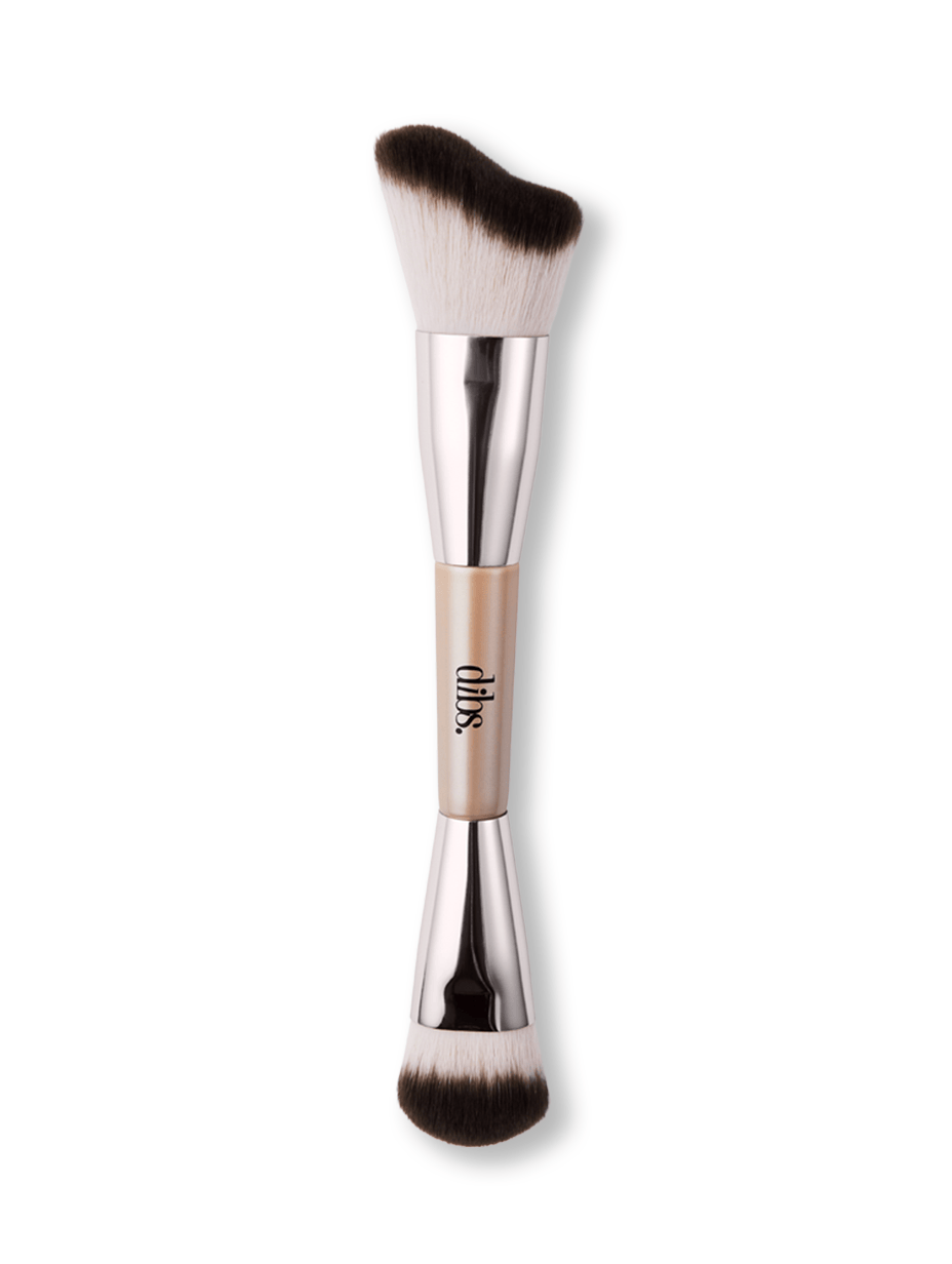 Double ended makeup brush with a silver handle and black bristles on a white background