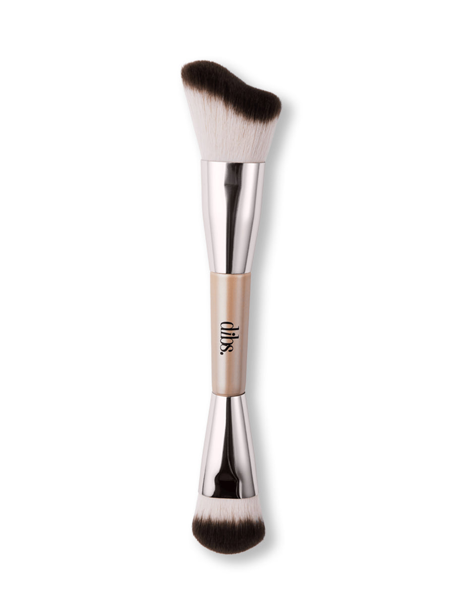 Double ended makeup brush with a silver handle and black bristles on a white background