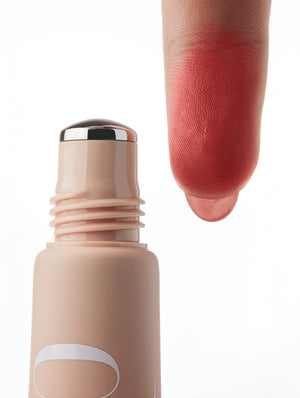 Cool Blush roller applicator with a swatch of reddish pink color on a finger against a white background