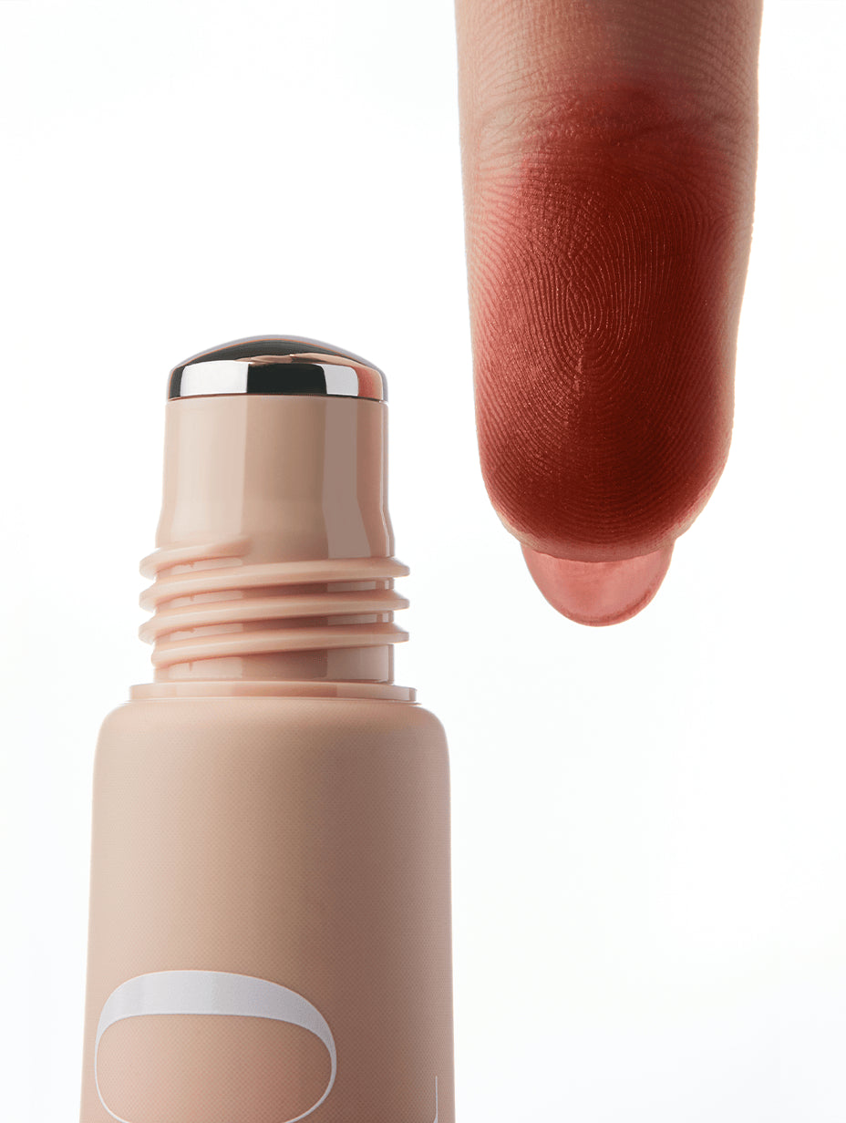 Cool Blush roller applicator with a swatch of brownish red color on a finger against a white background